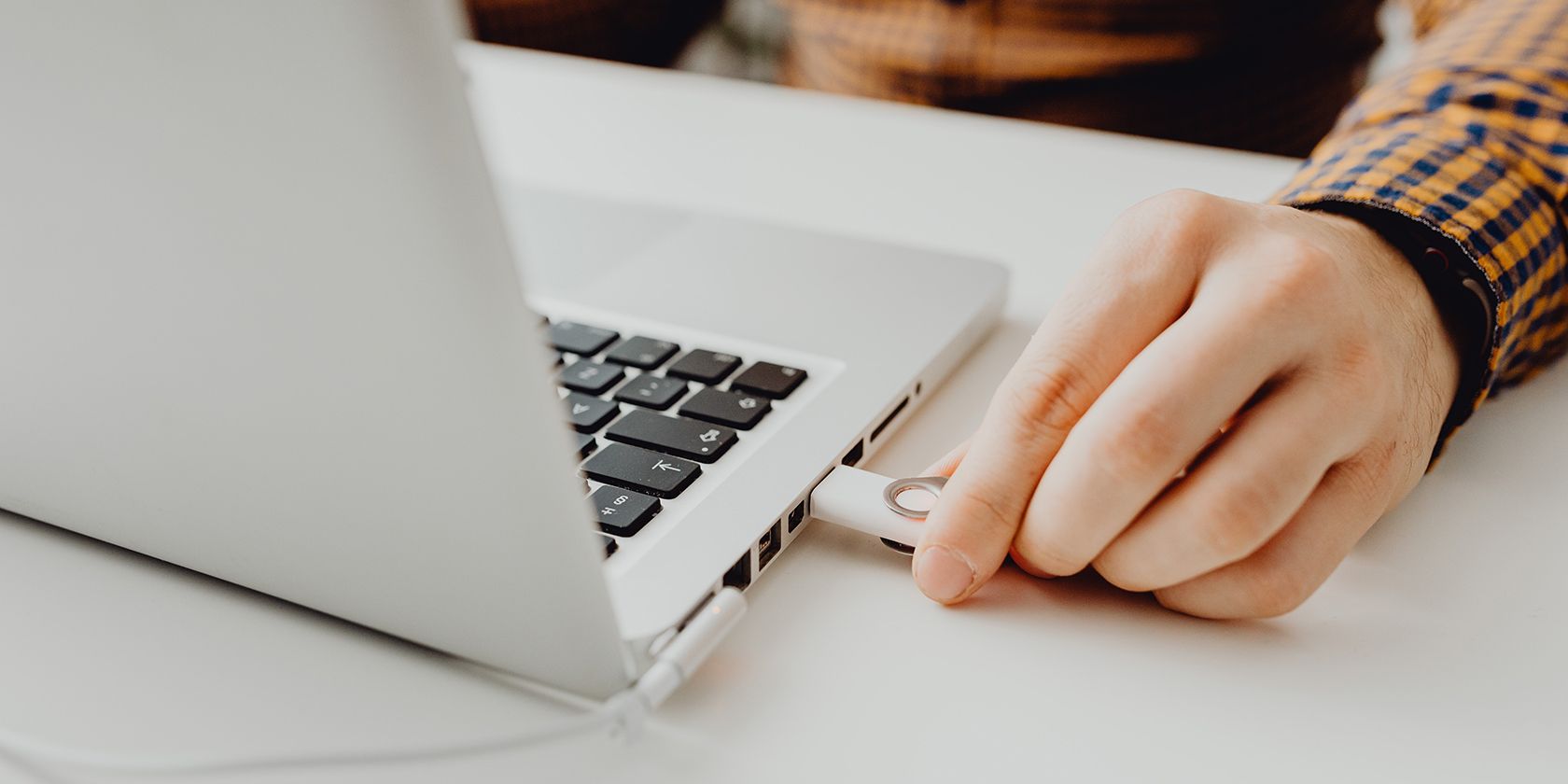 Person connecting a USB stick to a MacBook