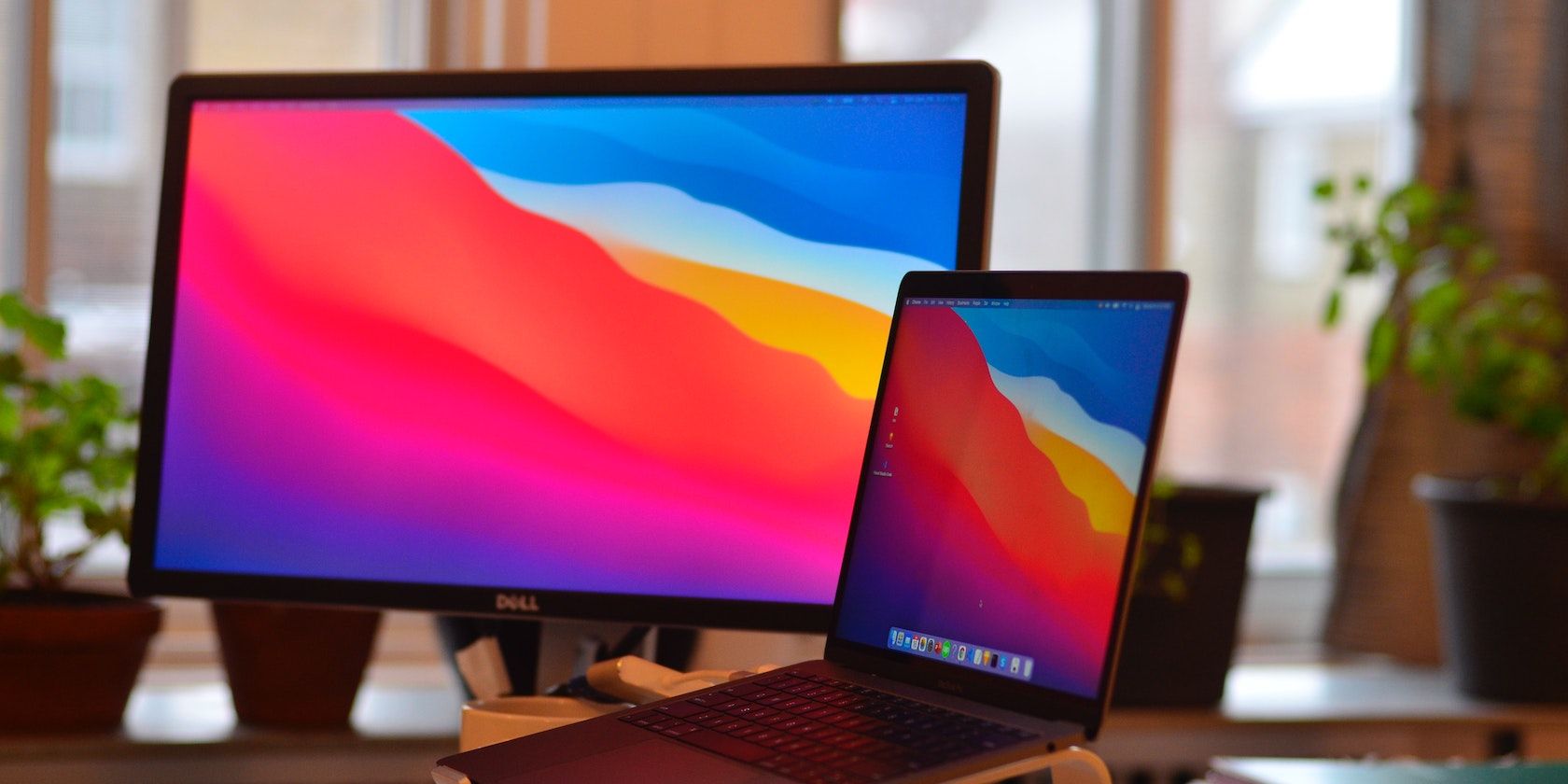 A photograph of a MacBook and a monitor showing Big Sur.