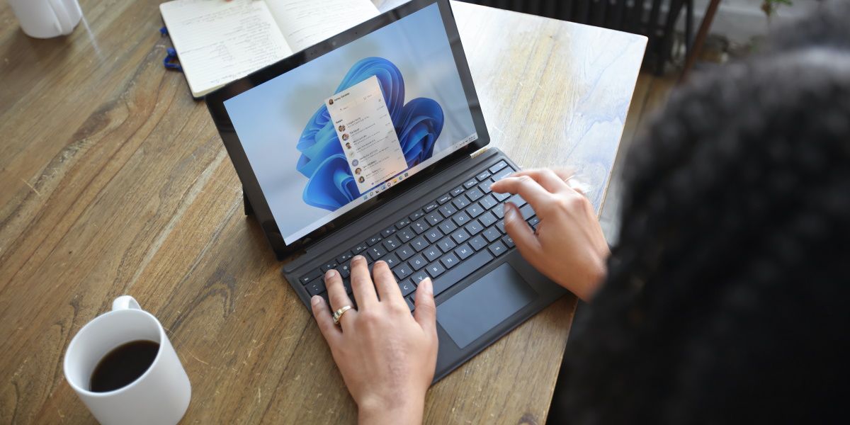 A person using a Windows computer on a brown desk