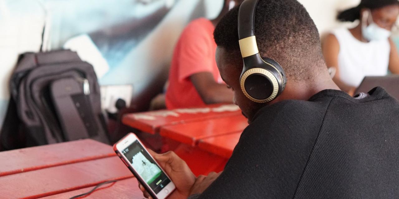 Man wearing hearphones listening to music on smartphone