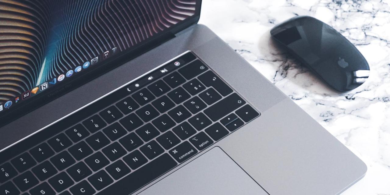 MacBook Pro with touchbar and Apple mouse on the right