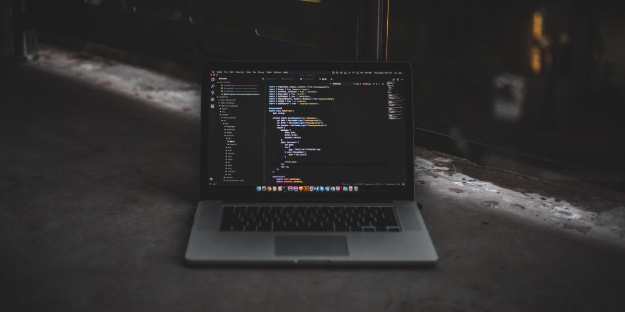 Code in VSCode on laptop sitting on the ground