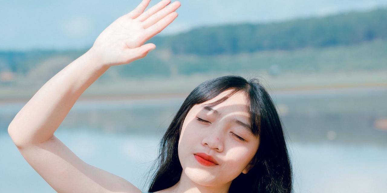 Woman holding up her hand to shield herself from the sun