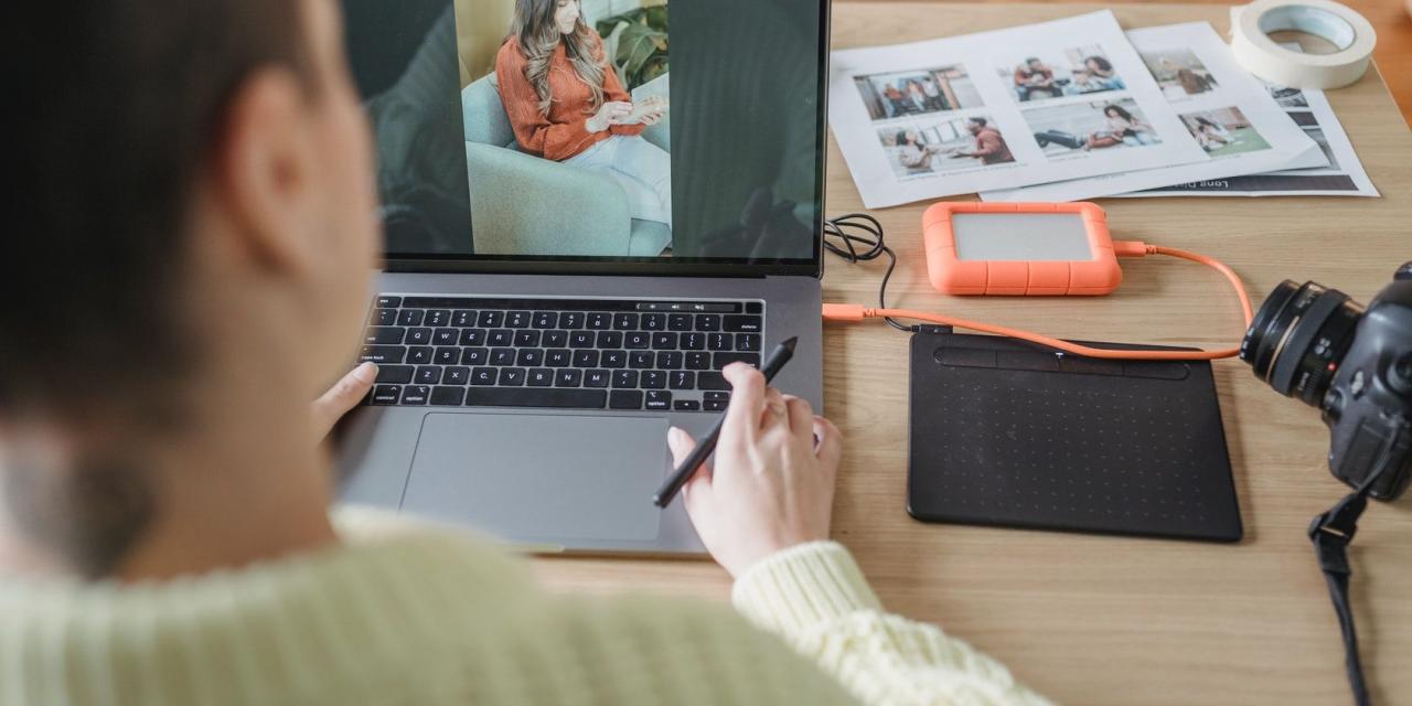 photo of a woman using an external hard drive with their computer