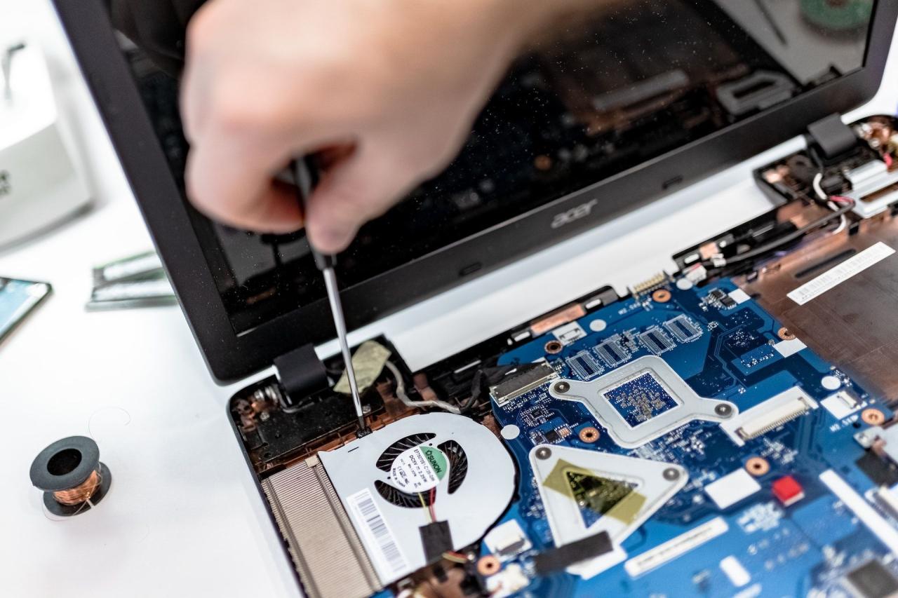 Image of a person fixing a laptop